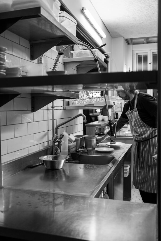 Contacto Arquetas Novalio Sevilla a man standing in a kitchen preparing food